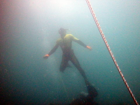 水中から水面に浮上する潜水士
